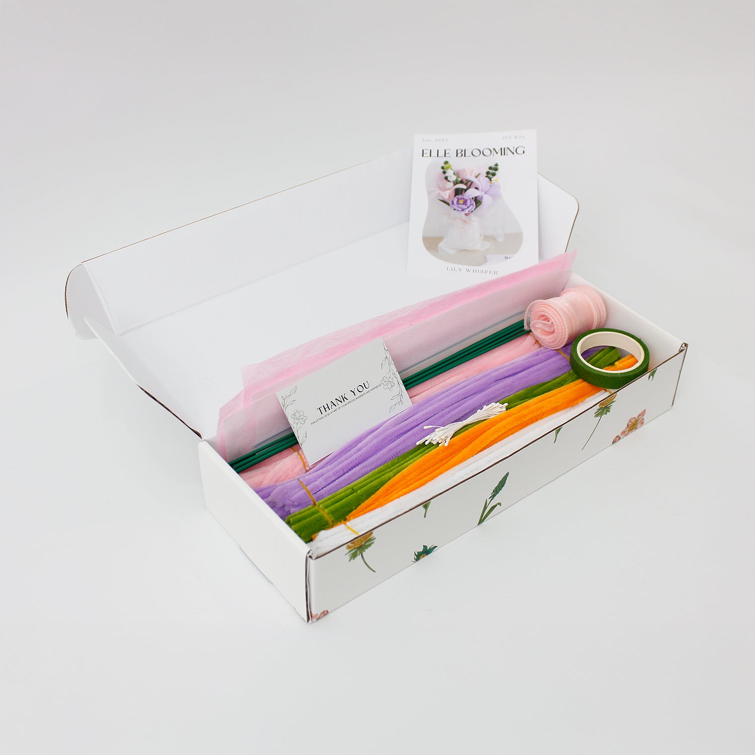 Lily Whisper DIY bouquet made from soft pipe cleaners, featuring pastel lilies, tulips, and a blooming purple carnation. Wrapped in sheer white and pink layers with a soft organza bow a handmade floral gift full of grace.