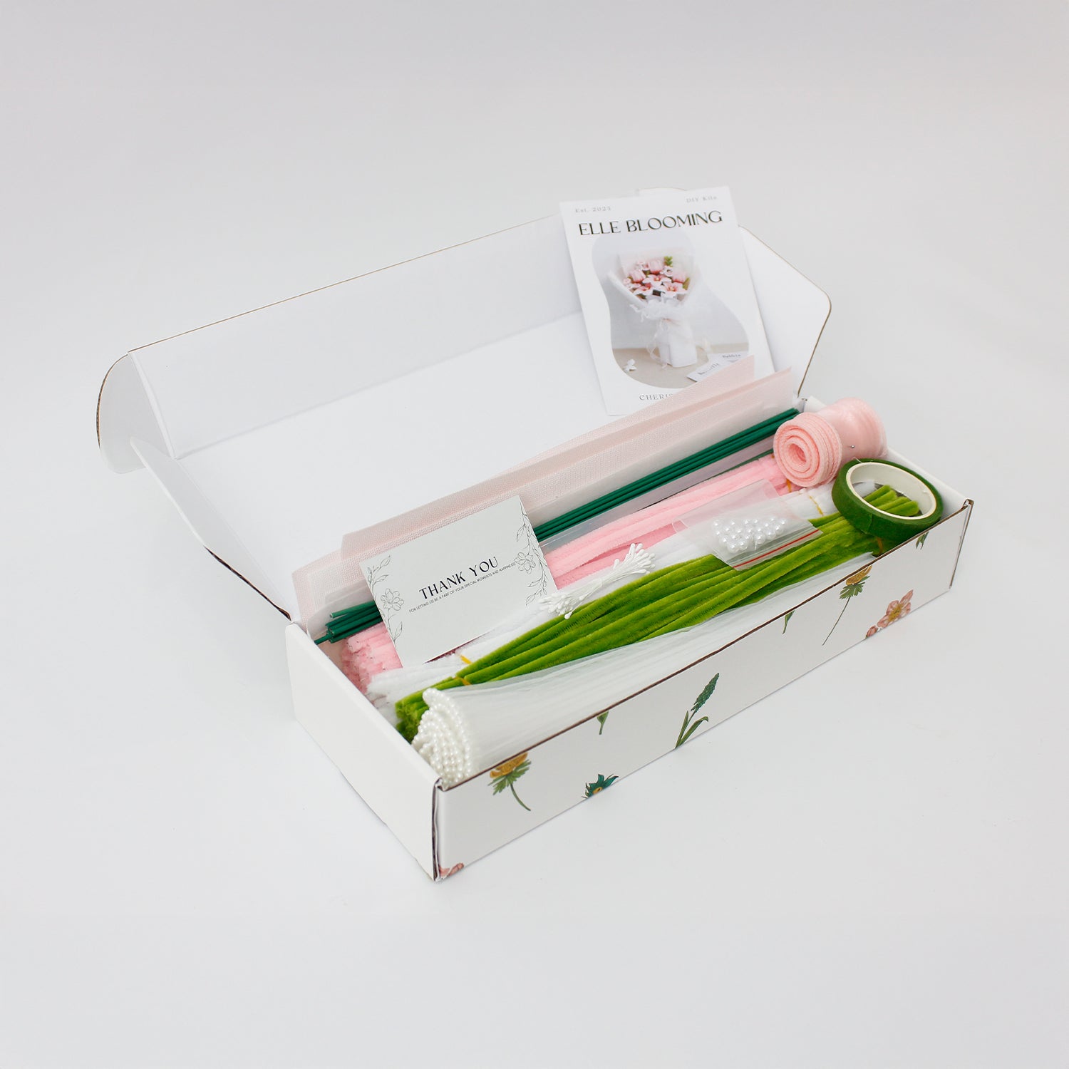 Cherish Tiger Lilies DIY bouquet featuring soft pink tiger lilies, tulips, and tiny blossoms made from pipe cleaners. Wrapped in layered pastel packaging with pearl-trimmed ruffles an elegant, handmade craft kit ideal for gifting.