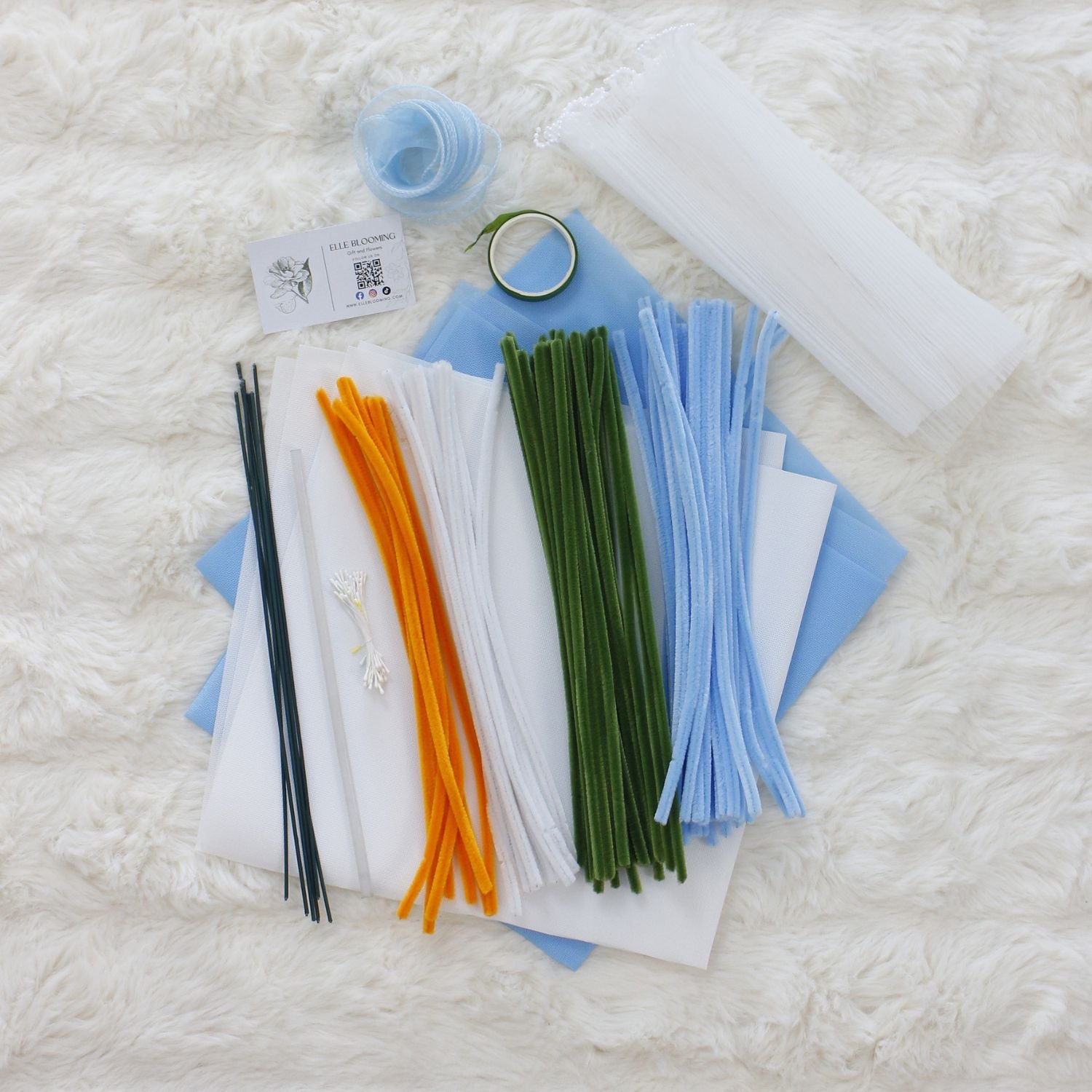 Baby Blue Lilies DIY bouquet made from soft pipe cleaners, featuring delicate white and blue lilies with greenery. Wrapped in pastel blue paper with a sheer ribbon a serene, handmade gift for any occasion.