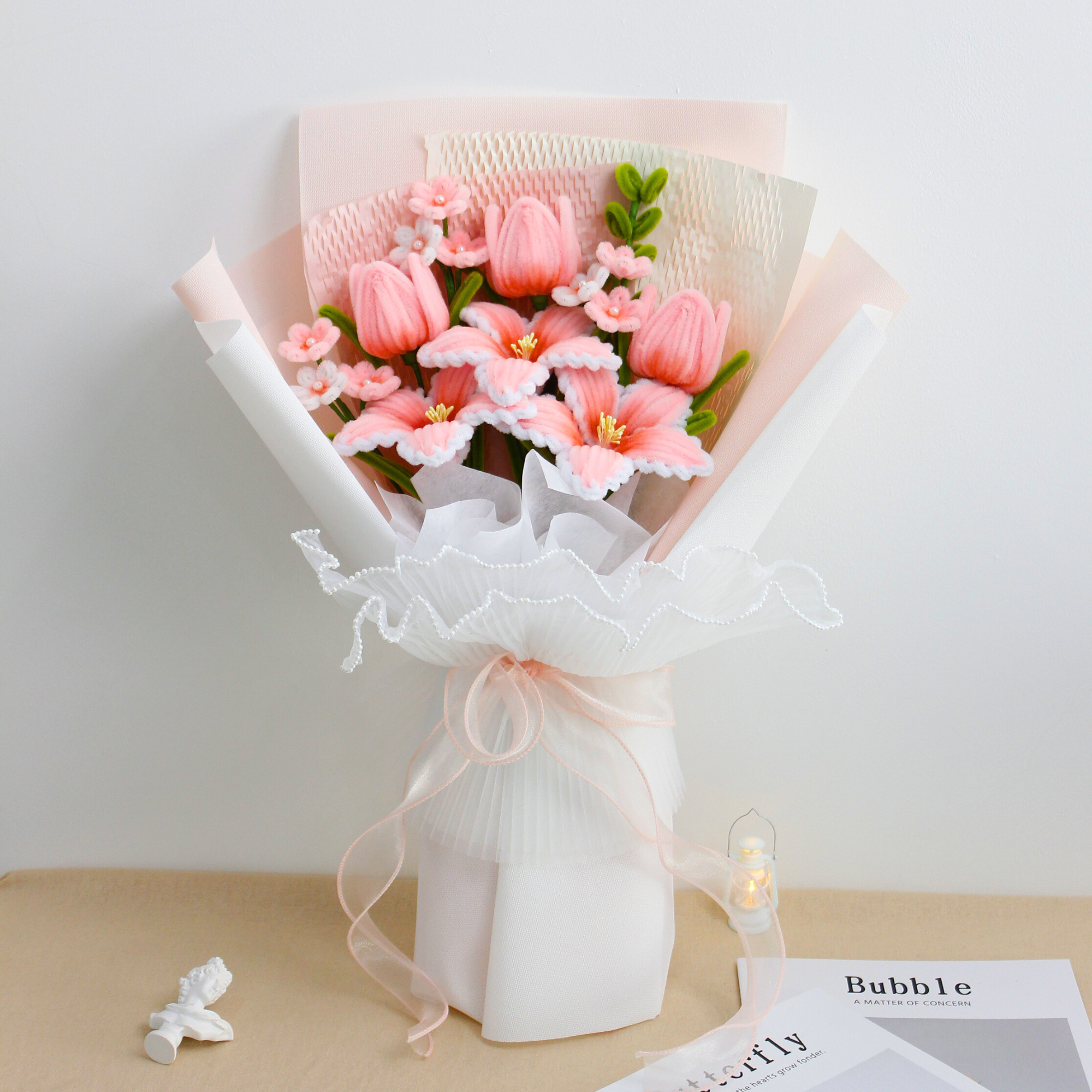 Cherish Tiger Lilies DIY bouquet featuring soft pink tiger lilies, tulips, and tiny blossoms made from pipe cleaners. Wrapped in layered pastel packaging with pearl-trimmed ruffles an elegant, handmade craft kit ideal for gifting.
