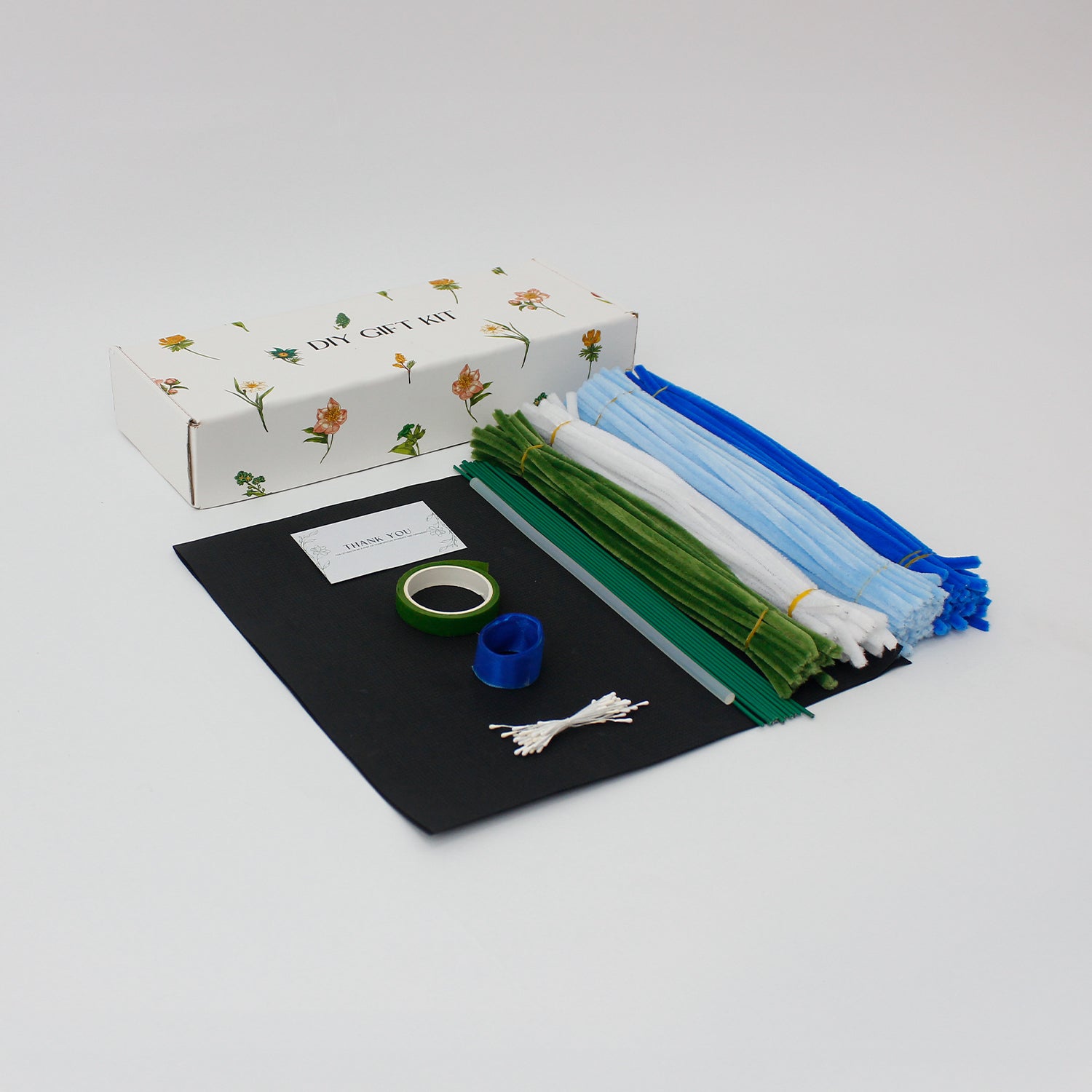 Bluence DIY bouquet with handmade blue, white, and light blue lilies crafted from pipe cleaners. Wrapped in sleek black paper with a royal blue ribbon, this elegant DIY floral kit is perfect for unique gifts and calming creative projects.